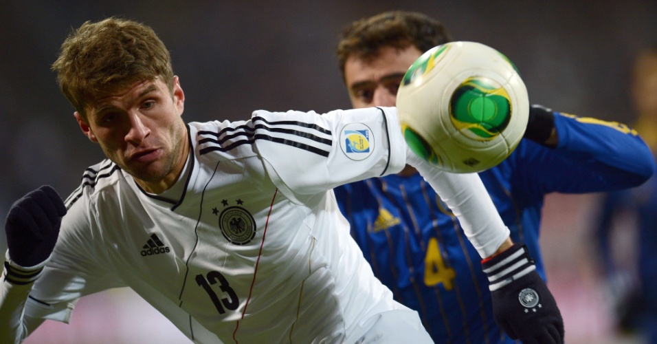 26.mar.2013 - Atacante Thomas Müller, da Alemanha, protege a bola de Moukhtar Moukhtarov durante partida contra o Cazaquistão, pelas eliminatórias europeias