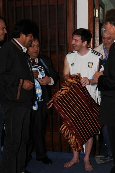 26.mar.2013 - Argentino Lionel Messi ganha roupas típicas do presidente boliviano, Evo Morales, depois do empate por 1 a 1 entre as seleções dos dois países
