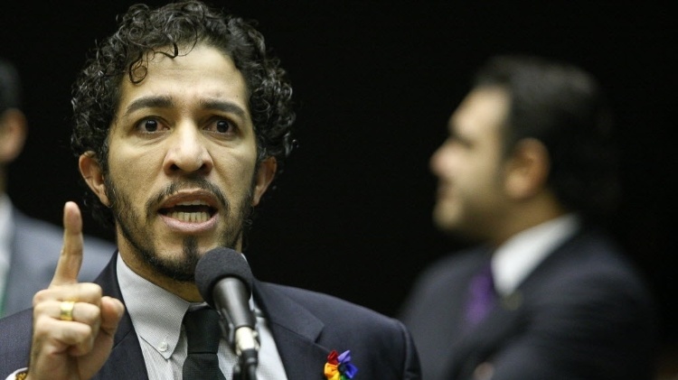 27.mar.2013 - Deputado Jean Wyllys (PSOL-RJ) discursa no plenário da Câmara dos Deputados, tendo ao fundo o deputado pastor Marco Feliciano (PSC-SP), presidente da Comissão de Direitos Humanos da Casa. - Sergio Lima/Folhapress - Sergio Lima/Folhapress