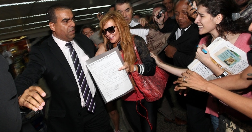 28.mar.2013 - Cercada por seguranças, Lindsay Lohan desembarca no aeroporto internacional de São Paulo. A atriz vai participar da festa de uma grife de roupas. Ela também visitará Florianópolis