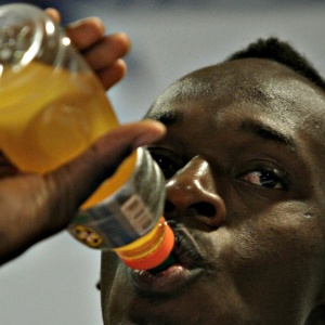 28.mar.2013 - Usain Bolt bebe isotônico de patrocinador durante coletiva no Rio de Janeiro, onde está para prova de 150 m, no próximo domingo, em Copacabana - Júlio César Guimarães/UOL