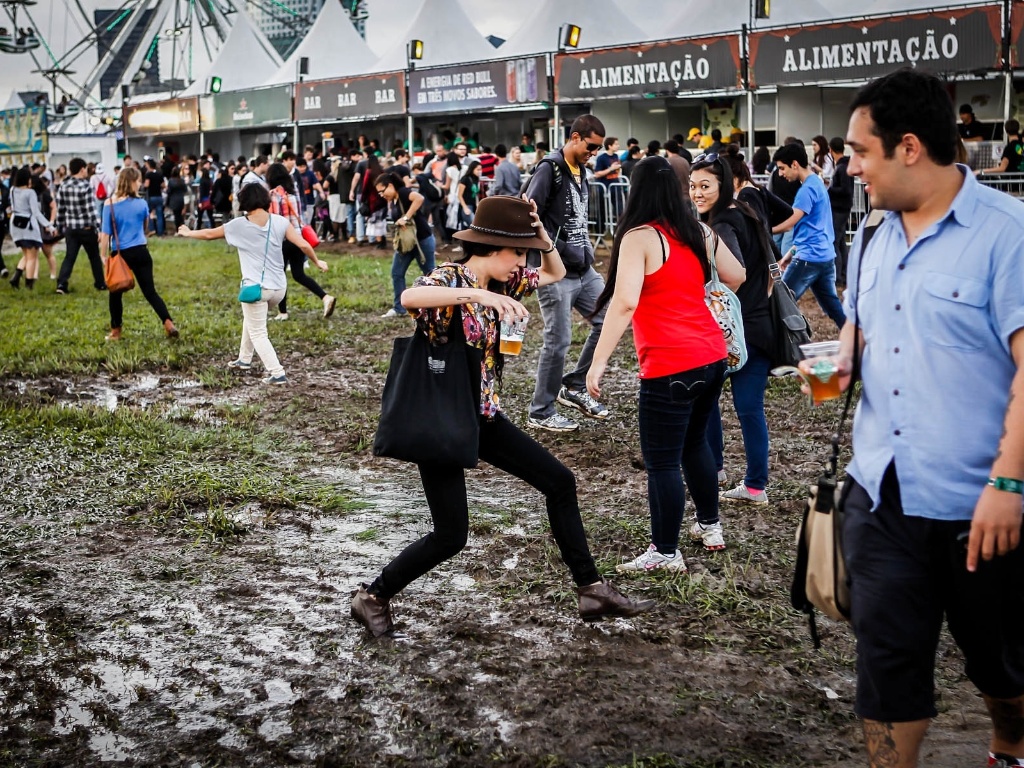 29.mar.2013 - O público do festival Lollapalooza faz o que pode para caminhar entre poças de água e lama durante o evento. Algumas pessoas reclamaram do cheiro de estrume - Leandro Moraes/UOL
