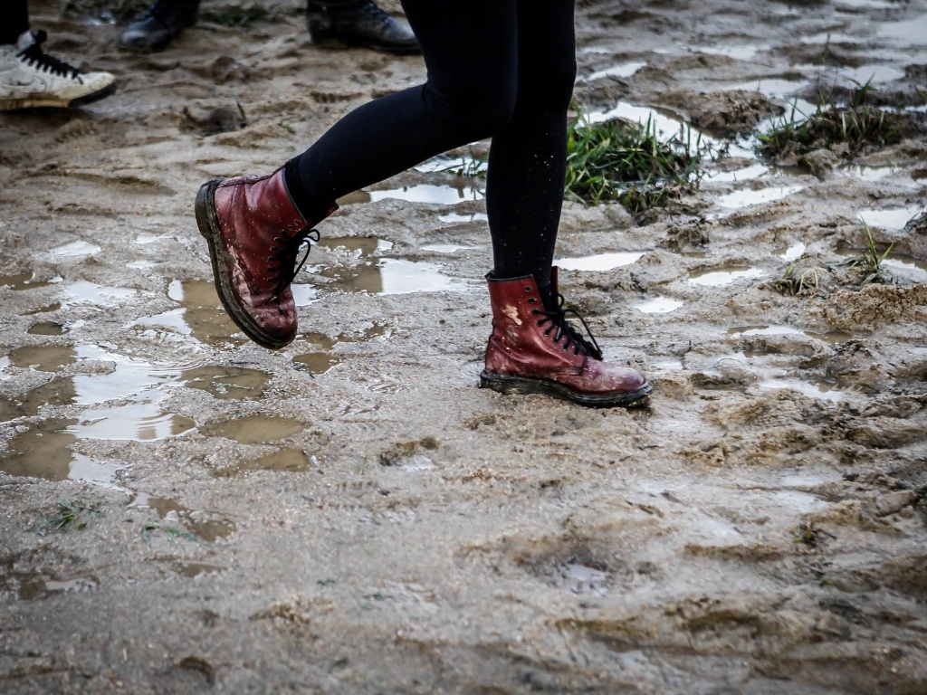 29.mar.2013 - O público do festival Lollapalooza faz o que pode para caminhar entre poças de água e lama durante o evento. Algumas pessoas reclamaram do cheiro de estrume - Leandro Moraes/UOL