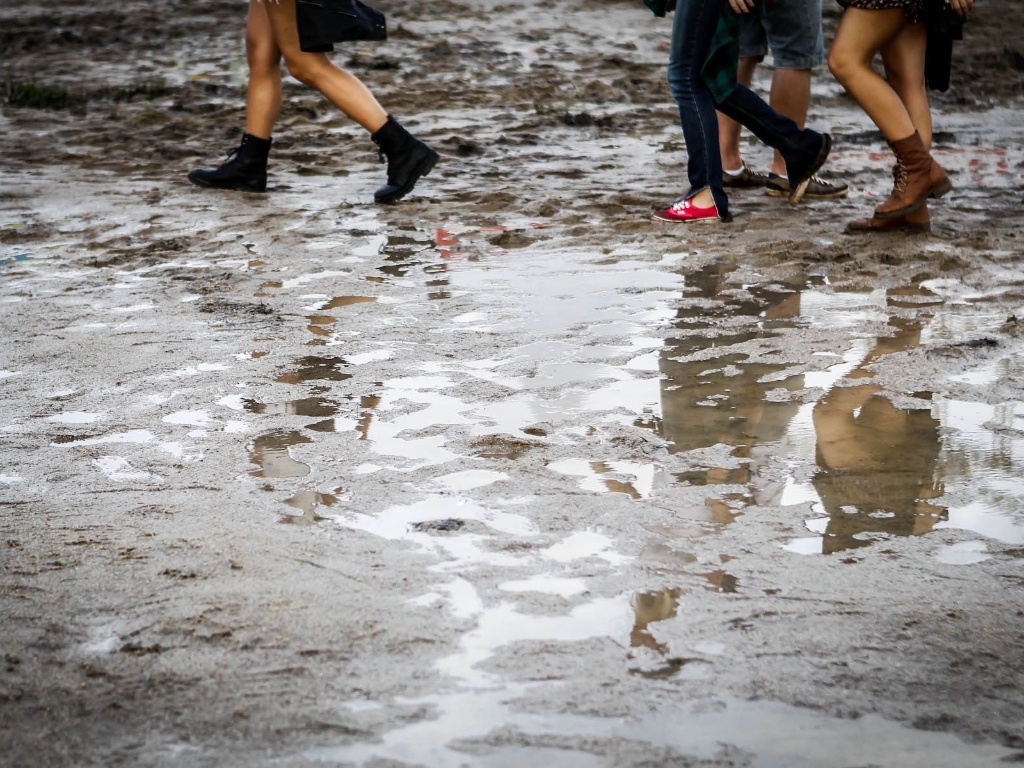 29.mar.2013 - O público do festival Lollapalooza faz o que pode para caminhar entre poças de água e lama durante o evento. Algumas pessoas reclamaram do cheiro de estrume - Leandro Moraes/UOL