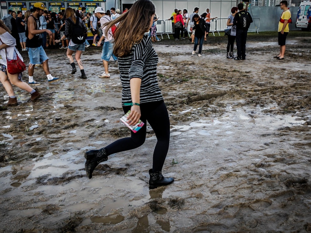 29.mar.2013 - O público do festival Lollapalooza faz o que pode para caminhar entre poças de água e lama durante o evento. Algumas pessoas reclamaram do cheiro de estrume - Leandro Moraes/UOL