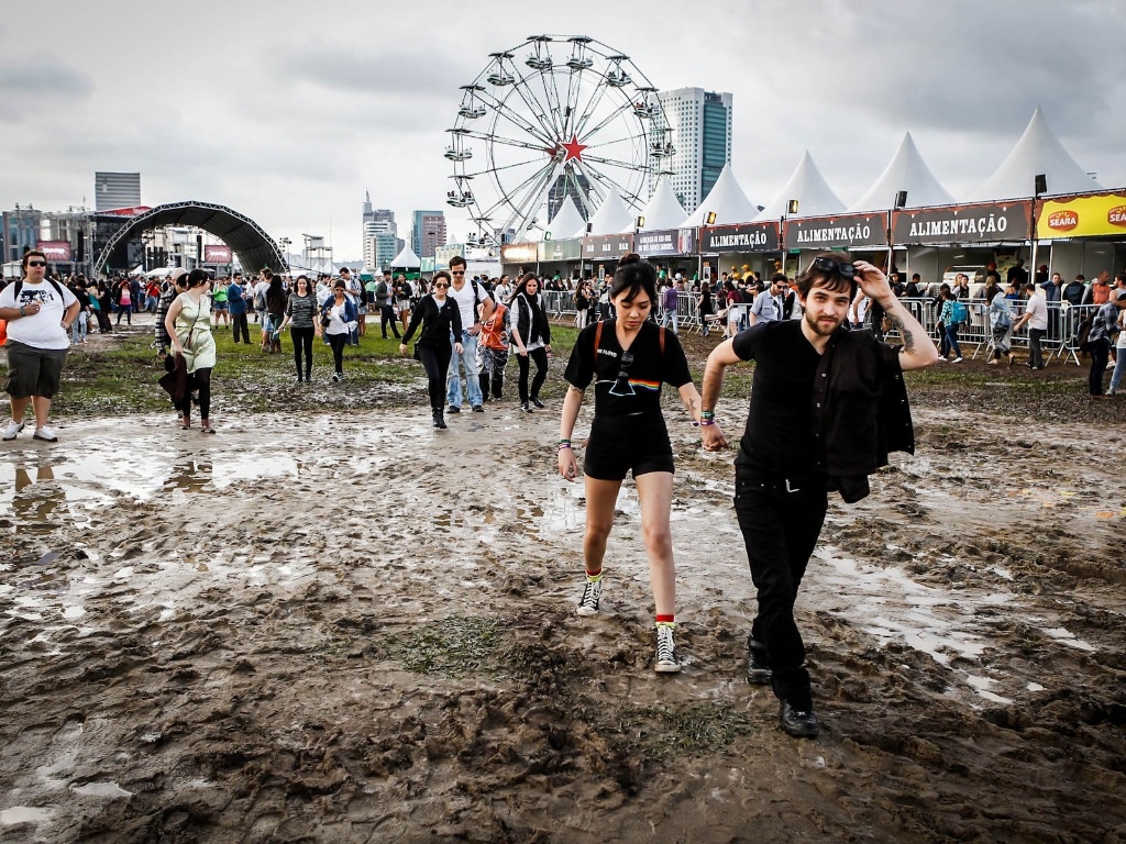 29.mar.2013 - O público do festival Lollapalooza faz o que pode para caminhar entre poças de água e lama durante o evento. Algumas pessoas reclamaram do cheiro de estrume - Leandro Moraes/UOL
