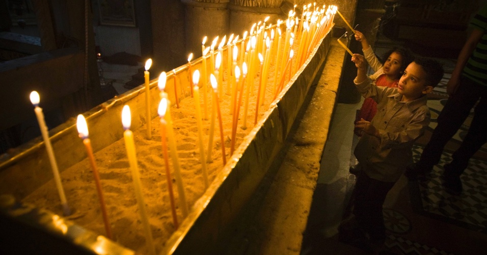 31.mar.2013 - Crianças acendem velas durante a missa do Domingo de Páscoa, na basílica do Santo Sepulcro, em Jerusalém