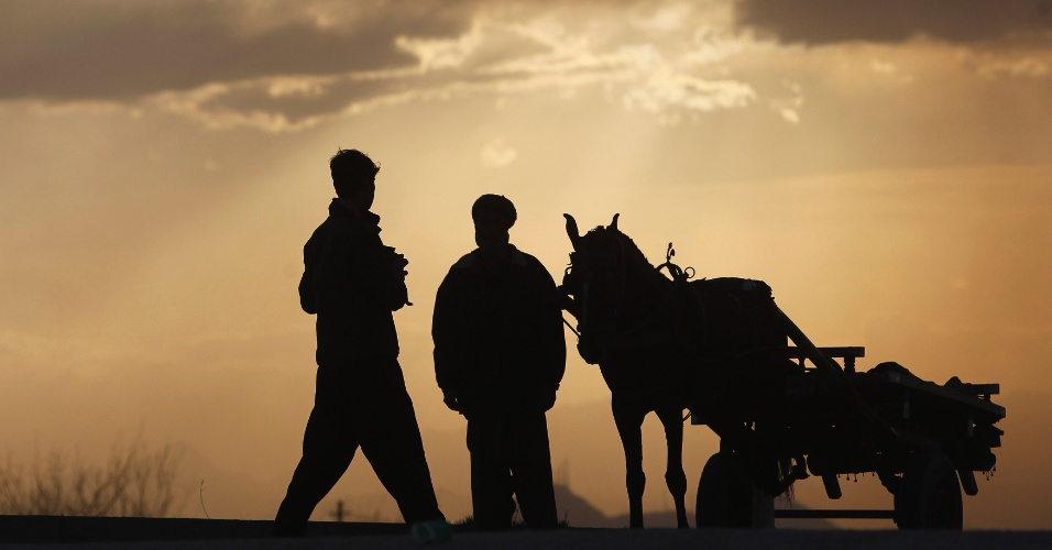 31.mar.2013 - Homens conversam próximos a uma carroça em Cabul, no Afeganistão