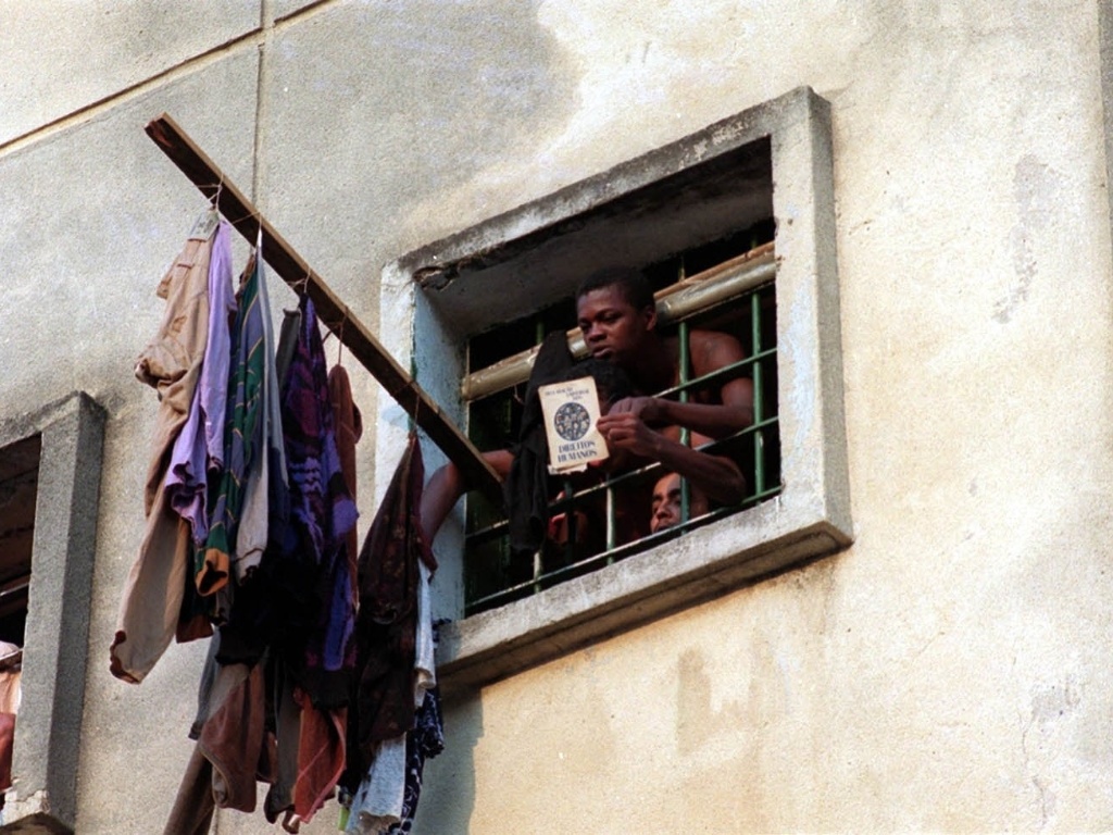 1º.abr.2013 - Detento do pavilhão 9 da Casa de Detenção mostra livro sobre direitos humanos - Luiz Carlos Murauskas/Folhapress