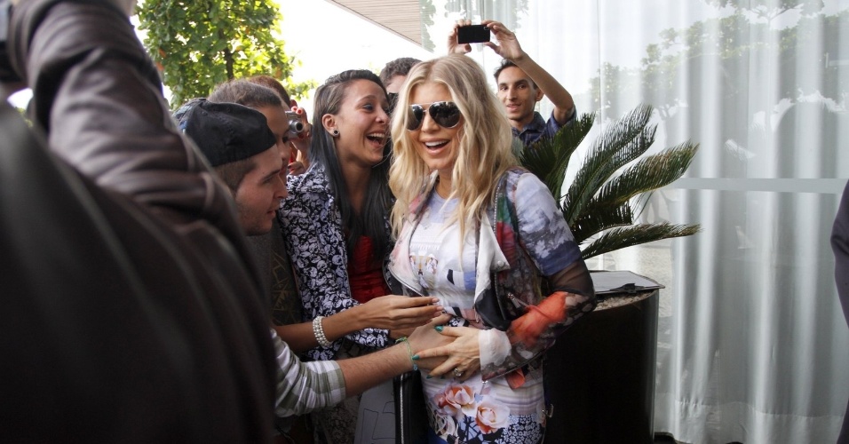 3.abr.2013 - Ao deixar o hotel onde está hospedada, na zona sul do Rio, Fergie foi tietada. A cantora posou para fotos e deixou um fã passar a mão em sua barriga. Ela está grávida do primeiro filho