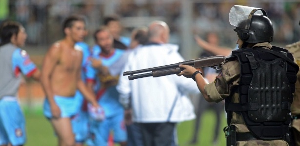 Policial aponta arma para jogadores do Arsenal durante confusão no Independência - AP Photo/Eugenio Savio