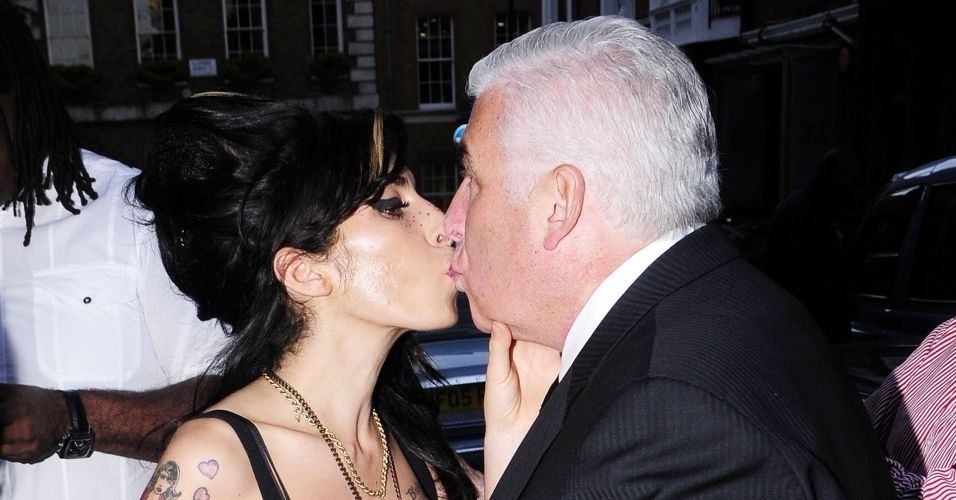 27.abr.2010: Dois dias depois de se recuperar de um acidente doméstico, Amy Winehouse demonstra seu carinho ao pai, Mitch Winehouse, durante um show do ex-taxista