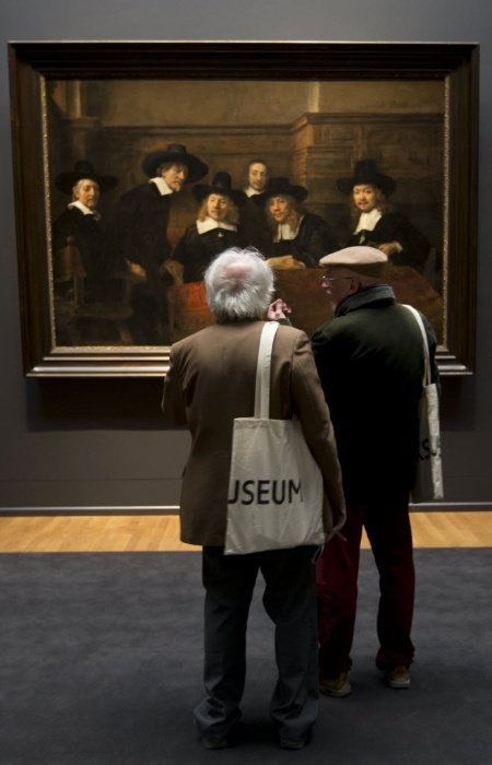 4.abr.2013 - Dois homens admiram quadro de Rembrandt conhecido como "Os Síndicos" durante prévia para a imprensa do renovado Rijkmuseum, em Amsterdã. O museu está se preparando para reabrir ao público geral no dia 13 de abril - AP Photo/Peter Dejong