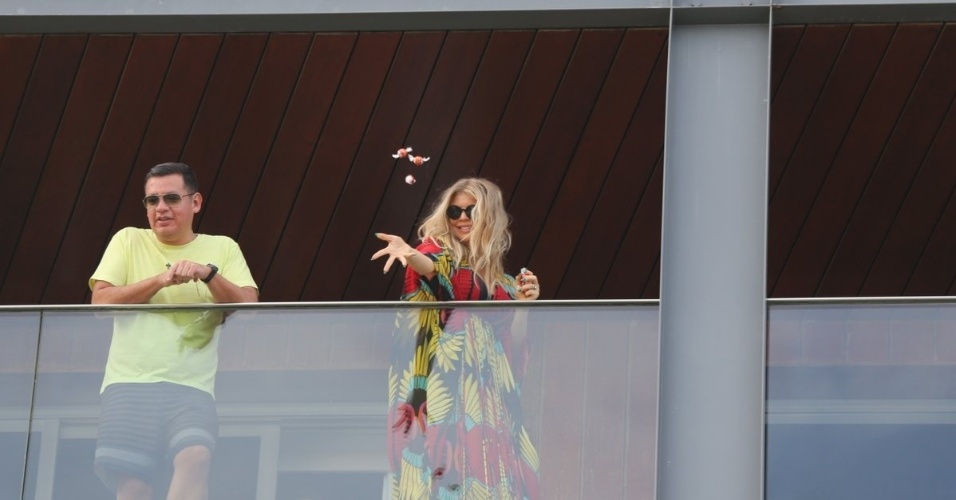 4.abr.2013 - Fergie joga bombons de chocolate para seus fãs no hotel Fasano, no Rio de Janeiro. A cantor está na capital carioca a convite da grife Hugo Boss