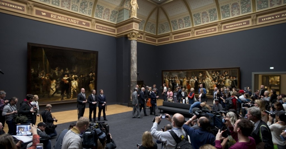 4.abr.2013 - Jornalistas tiram fotos e gravam vídeos enquanto dignatários como o diretor do Rijkmuseum Wim Pijbes posam em frente ao quadro  "A Ronda Noturna" ("De Nachtwacht"), do pintor holandês Rembrandt. O museu se prepara para reabrir para o público em geral a partir do dia 13 de abril - AP Photo/Peter Dejong