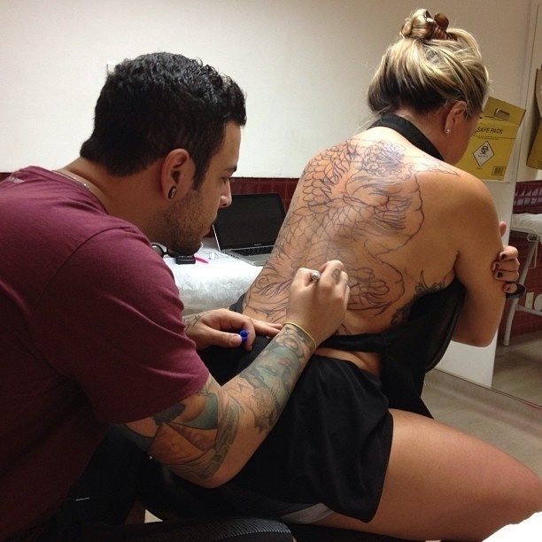 6.abr.2013 - Cristina Mortágua faz tatuagem nas costas