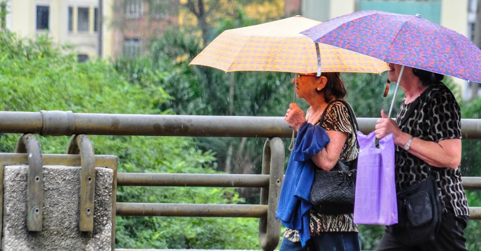 8.abr.2013 - Moradores de São Paulo (SP) se protegem da chuva no Viaduto do Chá, região central da cidade, na manhã desta segunda-feira