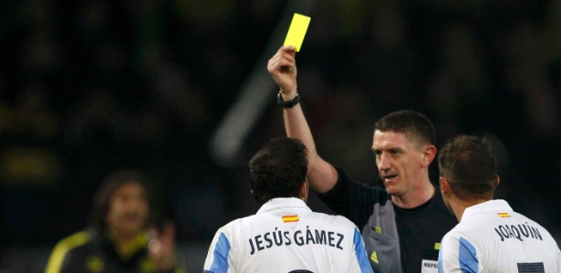 Craig Thomson dá cartão amarelo para jogador do Málaga, eliminado nesta terça  - REUTERS/Wolfgang Rattay