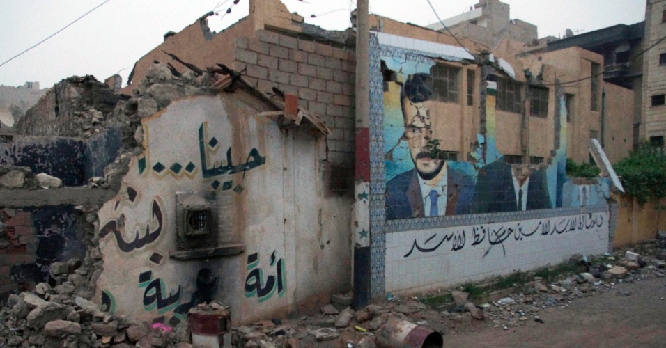9.abr.2013 - Muro destruído mostra pintura do ex-presidente da Síria Hafez al-Assad, pai de Bashar Assad, o atual presidente do país, em Deir al-Zor, nesta segunda-feira (8). A foto foi divulgada nesta terça-feira