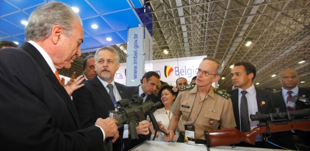 O vice-presidente da República, Michel Temer (à esq.) manuseia uma arma durante a Feira Internacional de Defesa e Segurança - Marco Antônio Teixeira/UOL