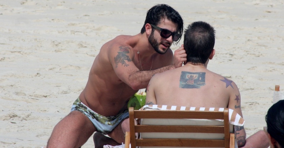 11.abr.2013 - O brasileiro Harry Louis acaricia o namorado, o estilista Marc Jacobs, na praia de Ipanema, na zona sul do Rio