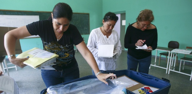 Funcionários do CNE (Conselho Nacional Eleitoral), o tribunal eleitoral venezuelano, preparam material para as eleições presidenciais que elegerão o sucessor de Hugo Chávez, no domingo (14), na Venezuela - Geraldo Caso/AFP