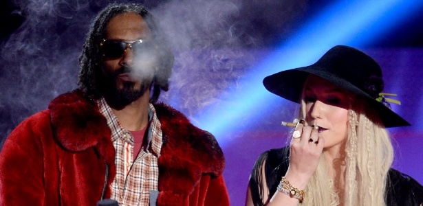 14.abr.2013 - Dividindo um cigarro, Snoop Lion e Ke$sha apresentam o show do rapper Macklemore no MTV Movie Awards 2013
