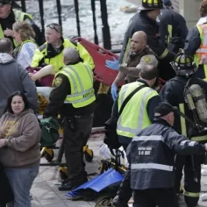 15.abr.2013 - Bombeiros e médicos prestam atendimento a feridos após explosão durante a Maratona de Boston - AP Photo/Charles Krupa
