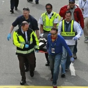 15.abr.2013 - Médicos prestam socorro a ferido após explosão ocorrida na Maratona de Boston - AP Photo/Charles Krupa