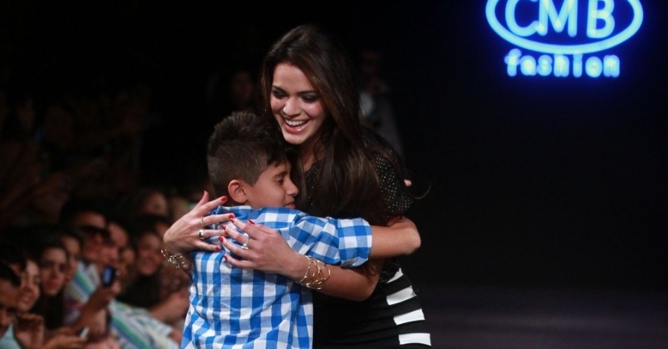 16.abr.2013 - Bruna Marquezine é agarrada por fã mirim durante desfile em Goiânia