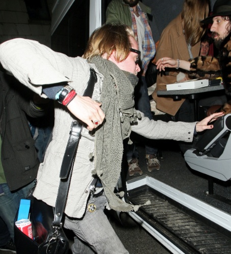 16.abr.2013 - O ator Macaulay Culkin empurra fotógrafos ao sair de uma casa noturna em Brighton, na Inglatera. Ele deixou o local escondendo o rosto com um par de óculos escuros e um cachecol verde