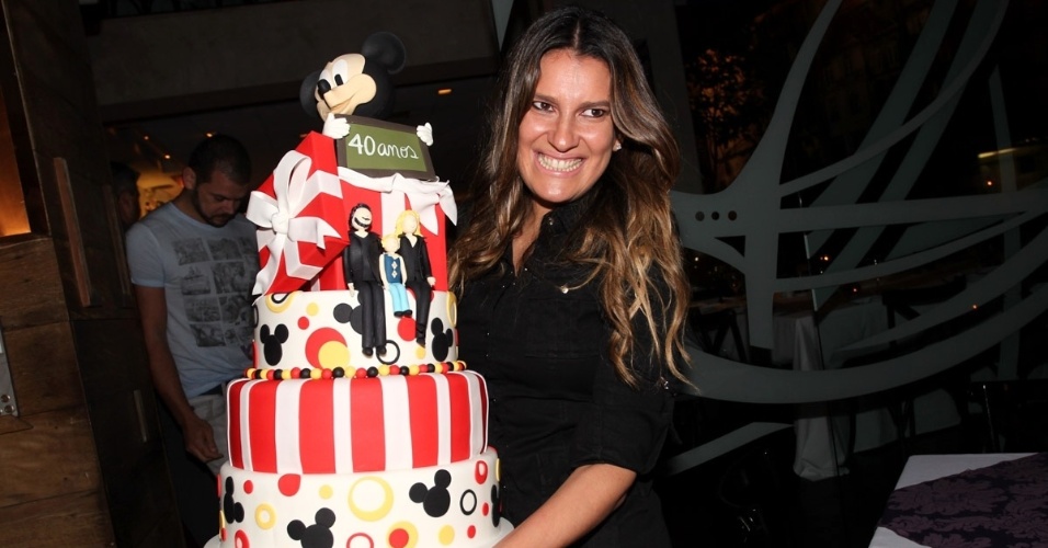 18.abr.2013 - Andréa Guimarães segura o bolo de aniversário de 40 anos de Adriane Galisteu em restaurante em SP