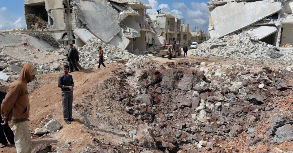 21.abr.2013 - Pessoas andam por casas destruídas no norte da cidade síria de Azaz. A União Europeia ofereceu um novo auxílio à oposição da Síria, aliviando um embargo de petróleo a favor dos rebeldes que lutam contra o presidente Bashar al-Assad, mas parou de fornecer armas ofensivas