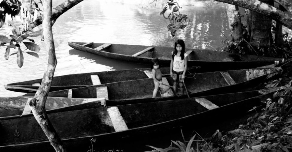 22.abr.2013 - Duas meninas brincam sozinhas em um dos portos da aldeia. A aldeia Lobo tem cerca de 400 habitantes, muitos deles jovens. Os povos indígenas lutam contra a crise populacional, iniciada com a colonização e que perdura até hoje. Consolidadas as atividades petrolíferas na fronteira com o Equador, o governo peruano acaba de conceder o direito de exploração de petróleo em dois lotes de terra encostados na fronteira com o Brasil, que rodeiam e abrangem território indígena demarcado - Lucas Bonolo/BBC