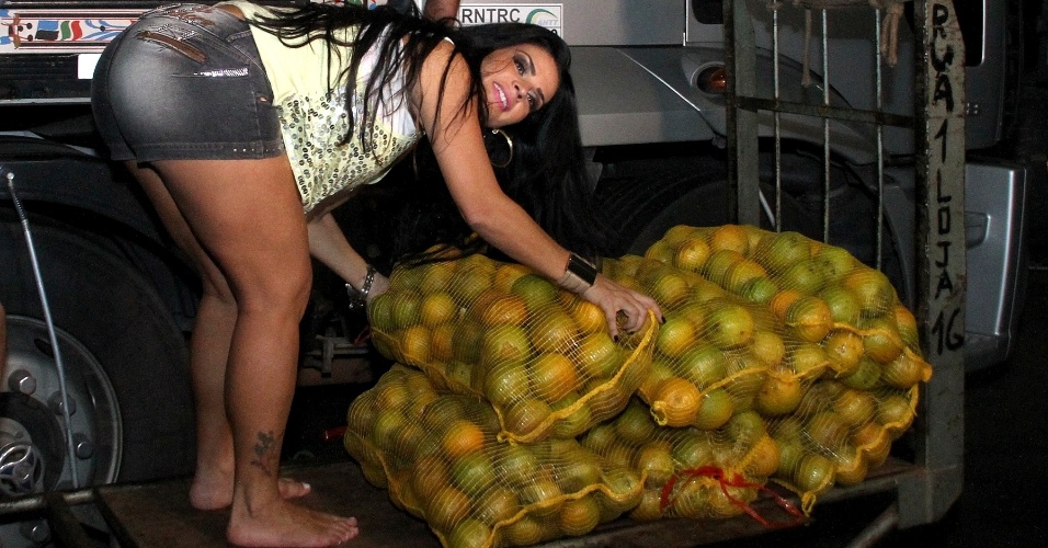 22.abr.2013 - Solange Gomes ajuda a descarregar laranjas de um caminhão no Cadeg, no Rio de Janeiro. A modelo viveu um dia de carregador de laranjas para o "Programa da Tarde", da Record