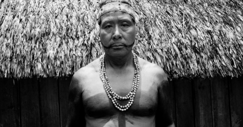 22.abr.2013 - Waki Mayuruma, cacique da aldeia Lobo, posa na frente de sua maloca (casa grande). Com espaço para mais de 400 pessoas, o espaço foi usado para sediar a quarta Reunião Binacional Matsés Brasil-Peru. Por décadas, os matsés, que vivem entre o Brasil e o Peru, ouviram histórias sobre a atuação de empresas petrolíferas nos vales tropicais do Equador e os problemas que elas causaram. "Dizem que petróleo dá dinheiro, mas não queremos dinheiro", afirma Waki Mayuruna, cacique da aldeia Lobo, a 2 mil quilômetros a oeste de Manaus. "Devemos pensar em nossos filhos e netos, e eles precisam de terras limpas" - Lucas Bonolo/BBC