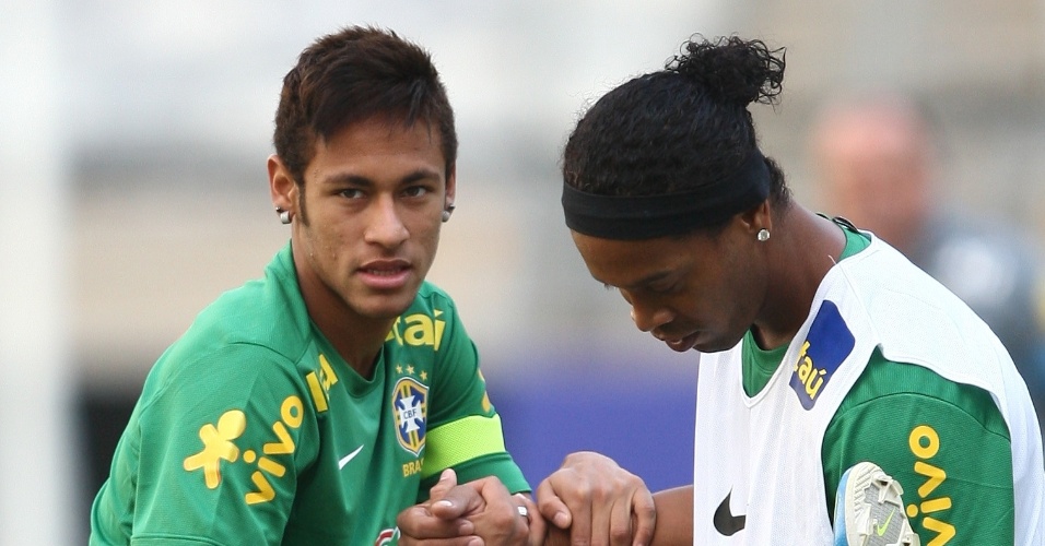 23.abr.2013 - Meia Ronaldinho Gaúcho ajuda o atacante Neymar no aquecimento no treino da seleção brasileira  no Mineirão
