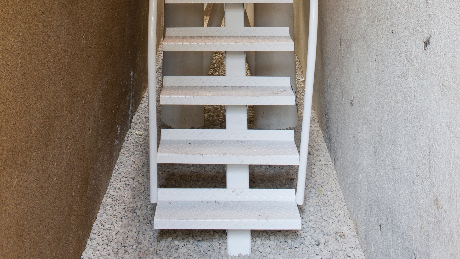 A escada de metal que leva ao alçapão da Casa Keret, em Varsóvia, Polônia. A pequena casa está "espremida" no espaço entre dois prédios - Andrea Meichsner/The New York Times