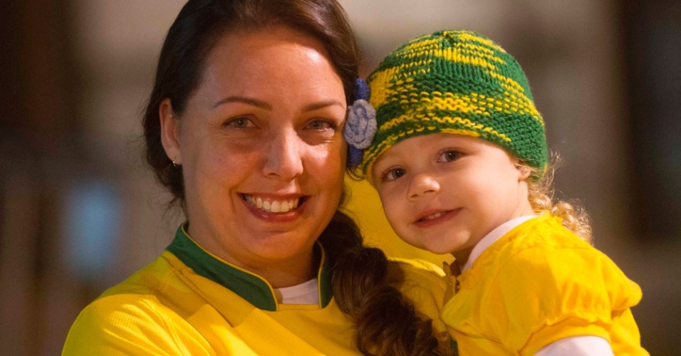 24.abr.2013 - Pequena torcedora é carregada por sua mãe em frente ao Mineirão, que receberá o amistoso entre Brasil e Chile