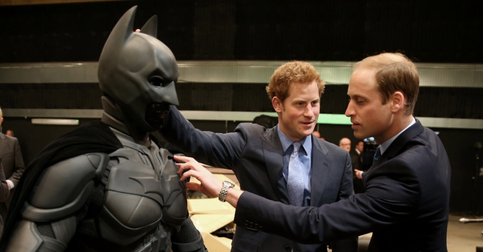 26.abr.2013 - Os príncipes Harry e William tocam na armadura do Batman durante visita aos estúdios Warner Bros Leavesden, em Londres