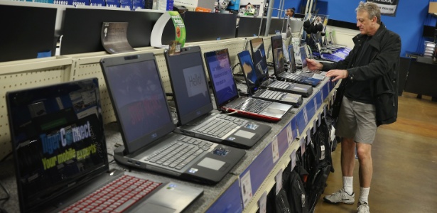 Homem observa prateleira com PCs em loja em Chicago nos EUA; venda de PCs tem caído a cada trimestre - Scott Olson/Getty Images/AFP