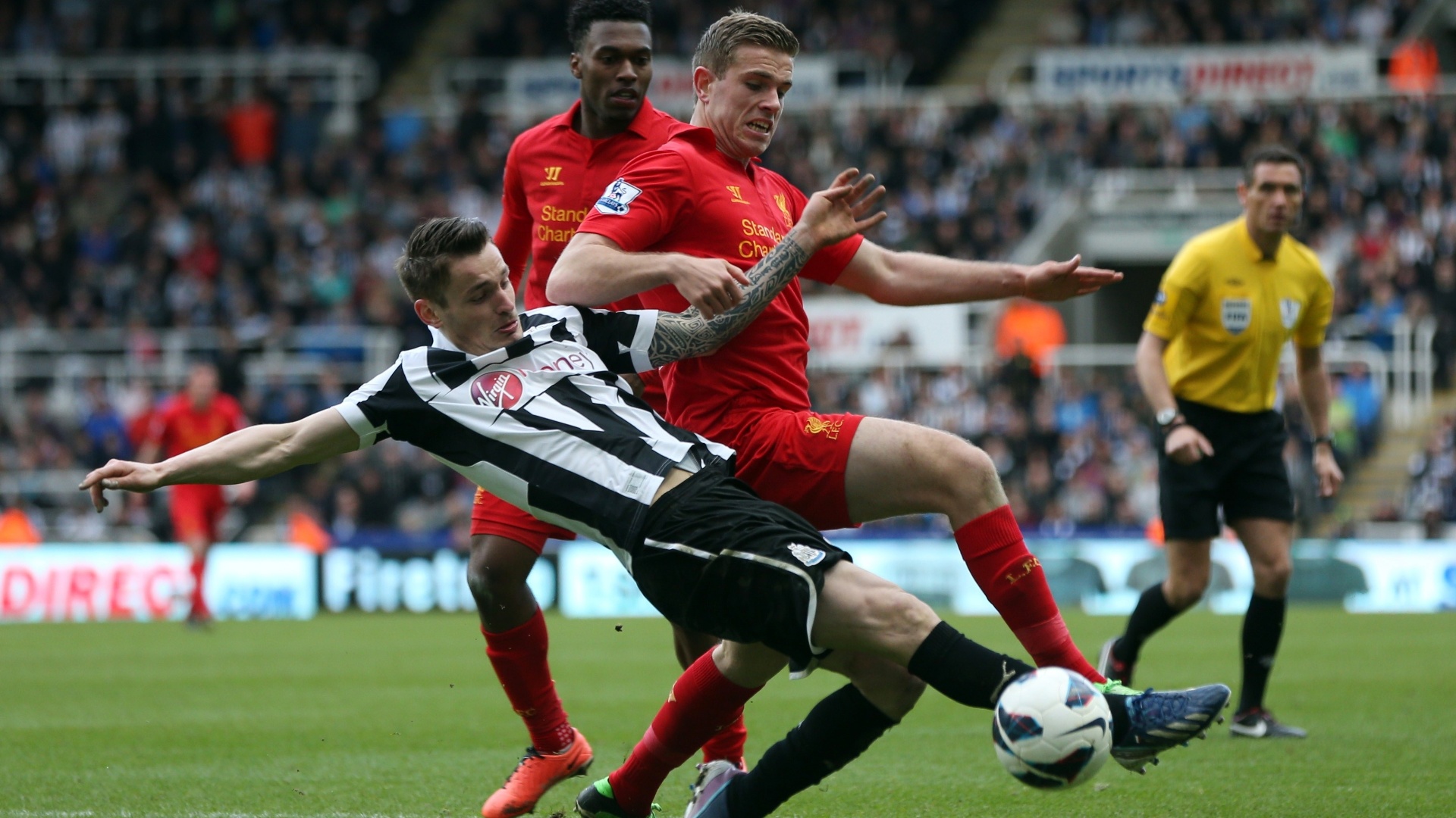 27.abr.2013 - O meia Henderson, do Liverpool, disputa jogada com o zagueiro Debuchy, do Newcastle, na partida pelo Campeonato Inglês - Ian Macnicol/AFP