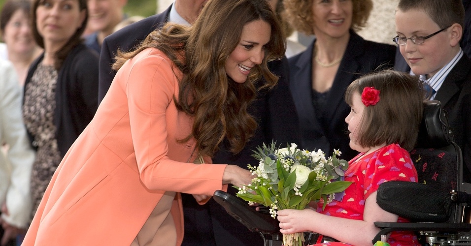 29.abr.2013 - Kate Middleton recebe flores de uma menina chamada Sally Evans ao visitar a instituição Naomi House, que cuida de crianças e adultos em estado terminal