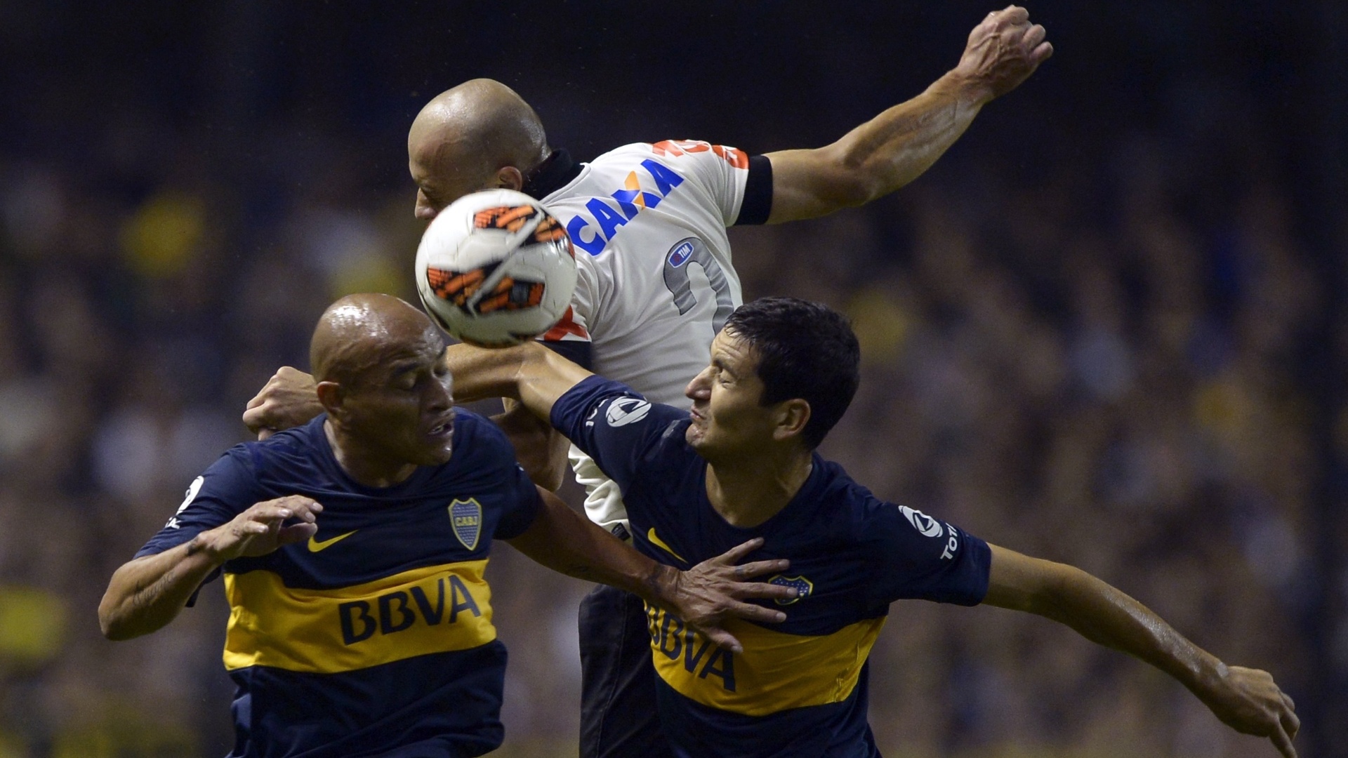 01.05.2013 - Alessandro disputa a bola pelo alto com dois jogadores do Boca Juniors - AFP PHOTO / Juan Mabromata