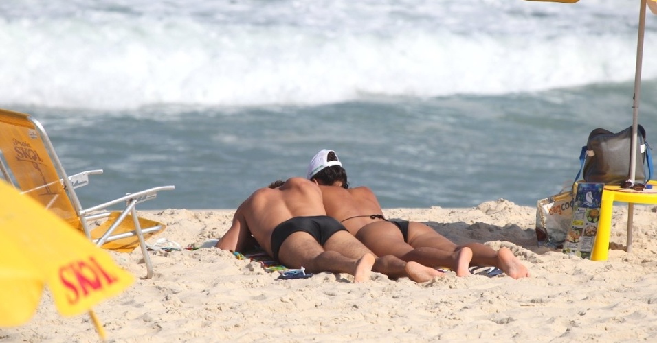 3.abr.2013 - O casal de atores Débora Nascimento e José Loreto aproveitaram a sexta de folga para tomarem sol e namorarem na praia da Reserva, no Rio