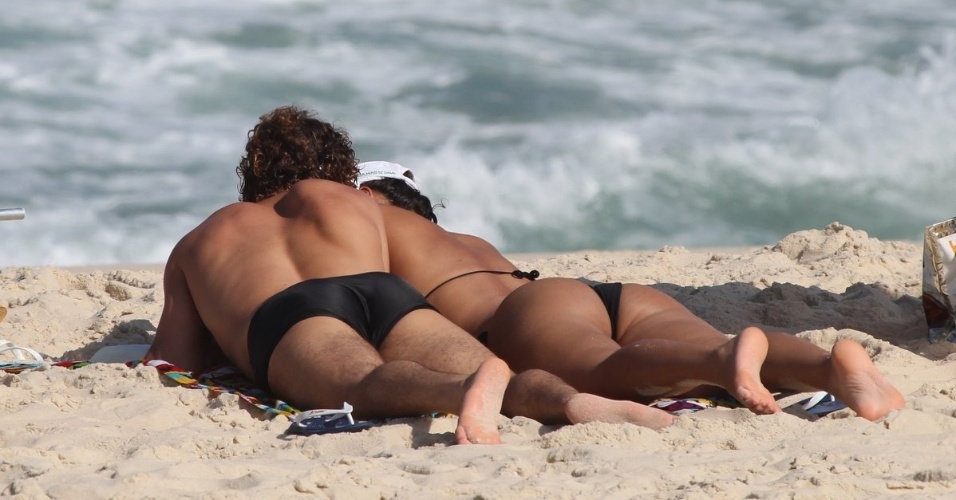 3.abr.2013 - O casal de atores Débora Nascimento e José Loreto aproveitaram a sexta de folga para tomarem sol e namorarem na praia da Reserva, no Rio