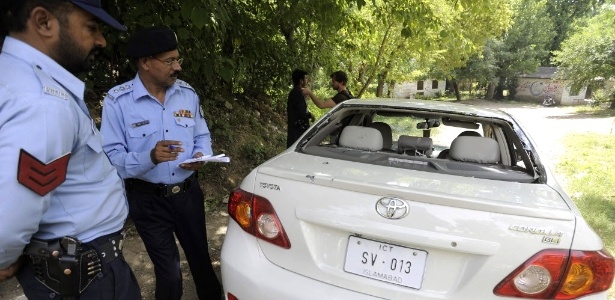 Policiais inspecionam carro onde o promotor Chaudhry Zulfiqar foi encontrado morto em Islamabad - T. Mughal/Efe
