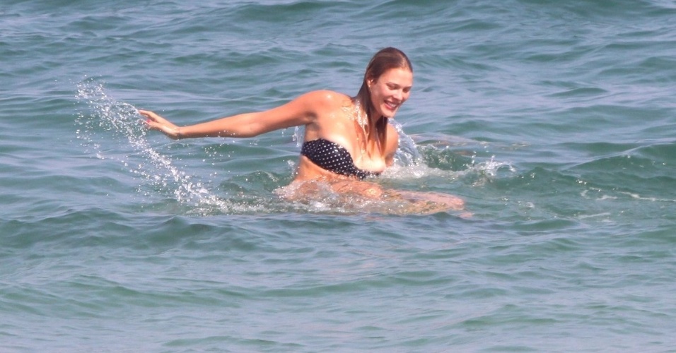 5.mai.2013 - A jogadora de vôlei Betina Schmidt deixa um dos seios à mostra durante mergulho com o jogador Roger Flores em praia do Rio. Roger separou-se recentemente da atriz Deboarh Secco