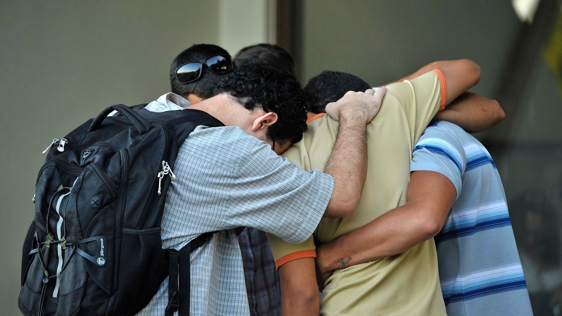 6.mai.2013 - Amigos do guitarrista Peu Sousa se abraçam durante velório do músico, morto neste domingo - João Alvarez/UOL