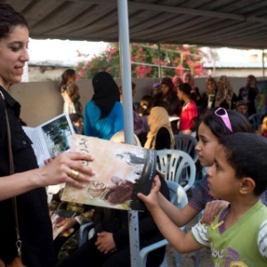 Roteirista da graphic novel "Budrus", Irene Nasser distribui livros em evento na aldeia palestina - Oren Ziv/Activestills.org